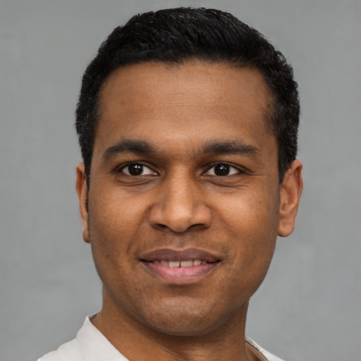 Joyful latino young-adult male with short  black hair and brown eyes