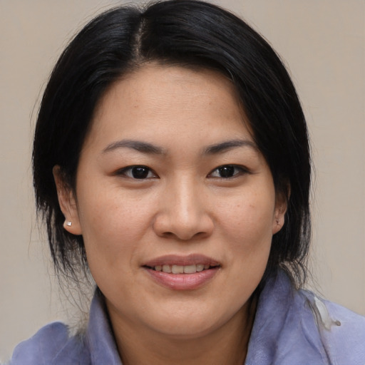 Joyful asian adult female with medium  black hair and brown eyes