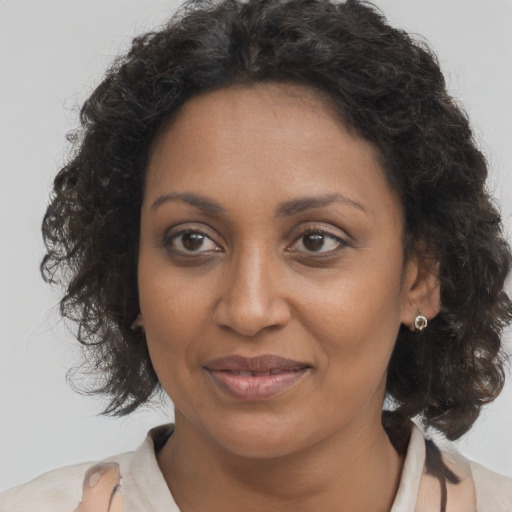 Joyful black adult female with medium  brown hair and brown eyes