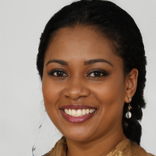 Joyful black young-adult female with long  black hair and brown eyes