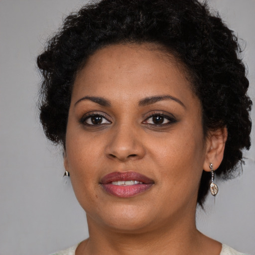 Joyful black adult female with short  brown hair and brown eyes