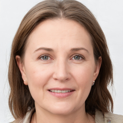 Joyful white adult female with medium  brown hair and grey eyes