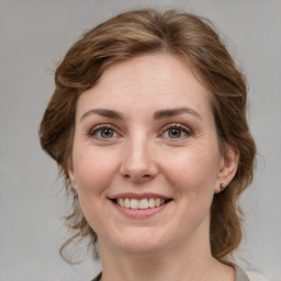 Joyful white young-adult female with medium  brown hair and green eyes