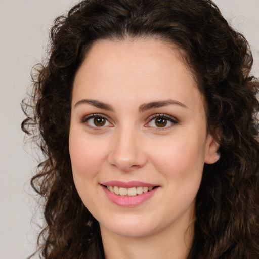 Joyful white young-adult female with long  brown hair and brown eyes