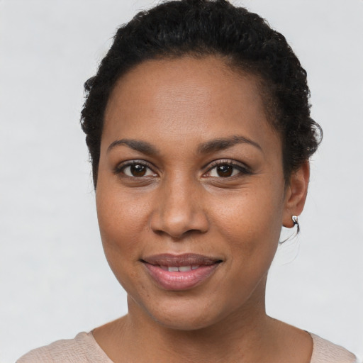 Joyful black young-adult female with short  brown hair and brown eyes
