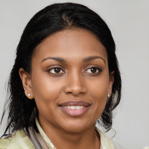 Joyful black young-adult female with medium  brown hair and brown eyes