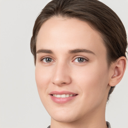 Joyful white young-adult female with medium  brown hair and grey eyes