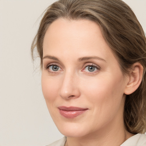 Joyful white young-adult female with medium  brown hair and green eyes