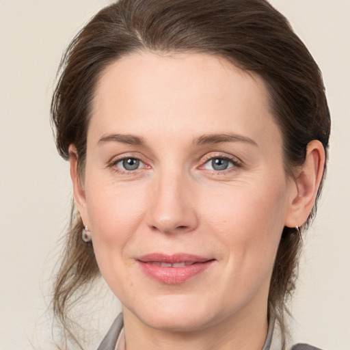 Joyful white young-adult female with medium  brown hair and grey eyes