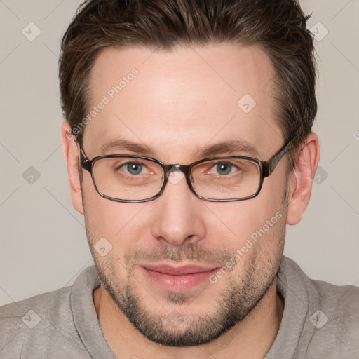 Joyful white young-adult male with short  brown hair and grey eyes