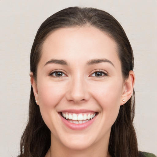 Joyful white young-adult female with long  brown hair and brown eyes