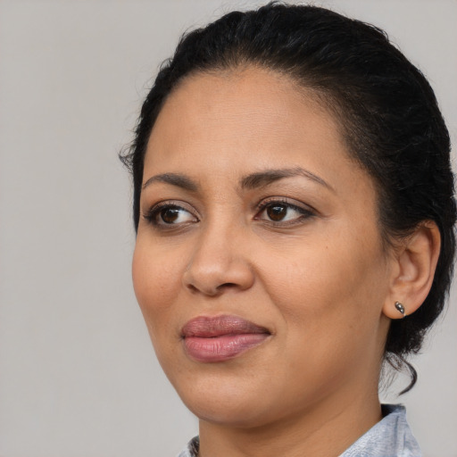 Joyful latino adult female with medium  brown hair and brown eyes