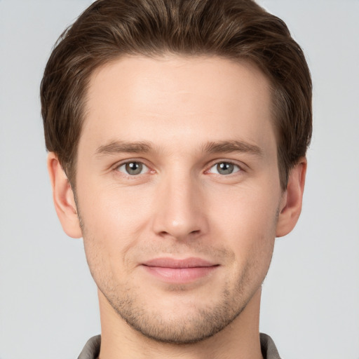 Joyful white young-adult male with short  brown hair and grey eyes