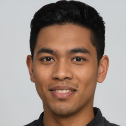 Joyful latino young-adult male with short  black hair and brown eyes