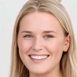 Joyful white young-adult female with long  brown hair and blue eyes