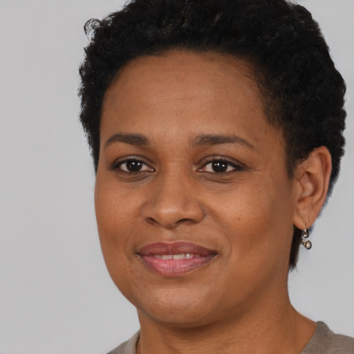 Joyful black young-adult female with short  brown hair and brown eyes