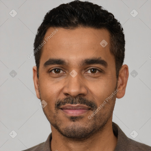 Joyful latino young-adult male with short  black hair and brown eyes