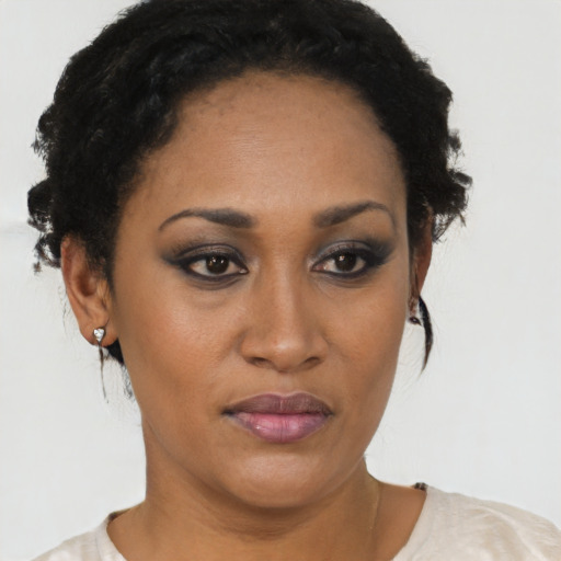 Joyful black adult female with short  black hair and brown eyes