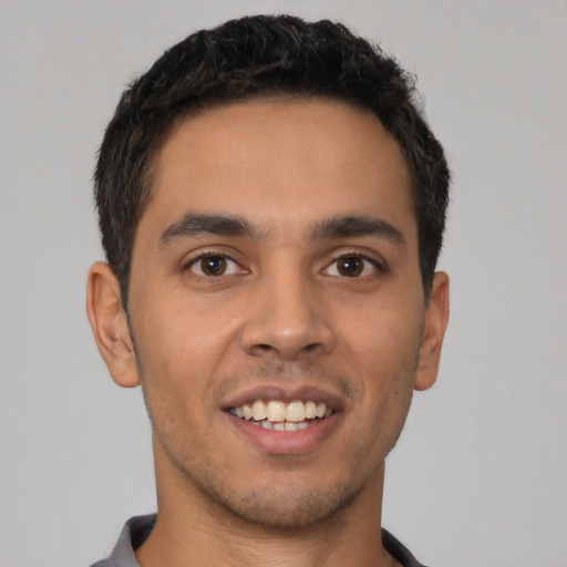 Joyful latino young-adult male with short  brown hair and brown eyes