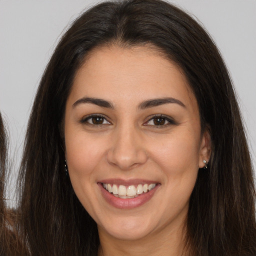 Joyful white young-adult female with long  brown hair and brown eyes
