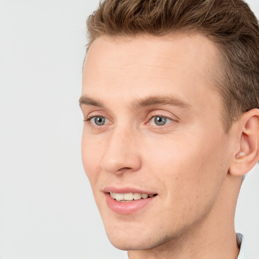 Joyful white young-adult male with short  brown hair and blue eyes