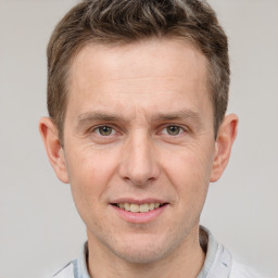 Joyful white adult male with short  brown hair and grey eyes