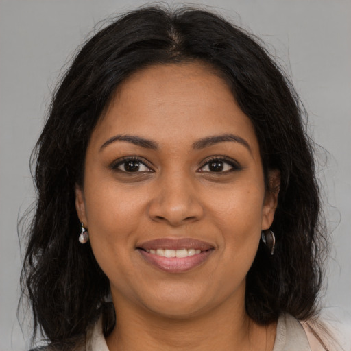 Joyful black young-adult female with long  brown hair and brown eyes