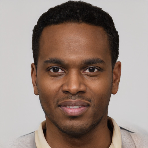 Joyful black young-adult male with short  black hair and brown eyes