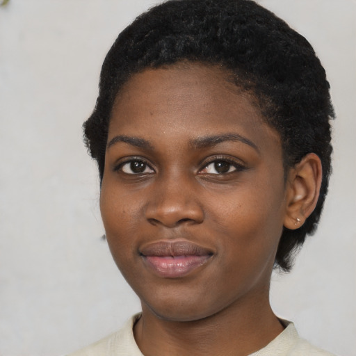 Joyful black young-adult female with short  black hair and brown eyes