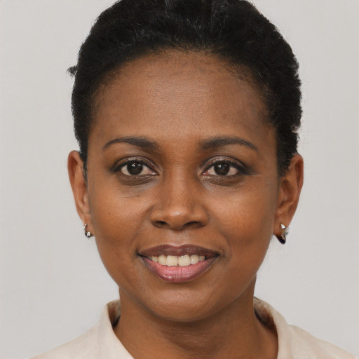 Joyful black young-adult female with short  brown hair and brown eyes