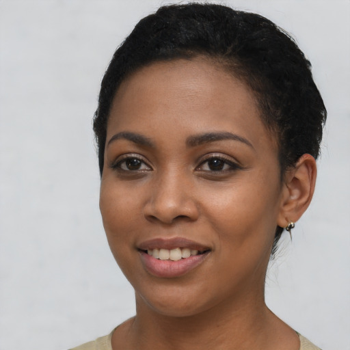Joyful black young-adult female with short  black hair and brown eyes