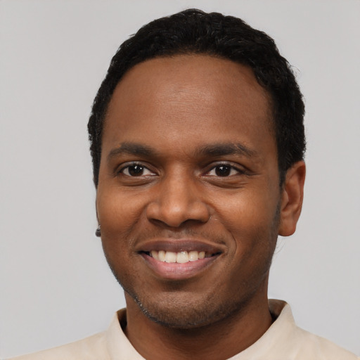 Joyful black young-adult male with short  black hair and brown eyes