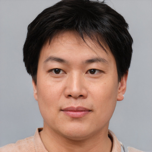 Joyful asian young-adult male with short  brown hair and brown eyes