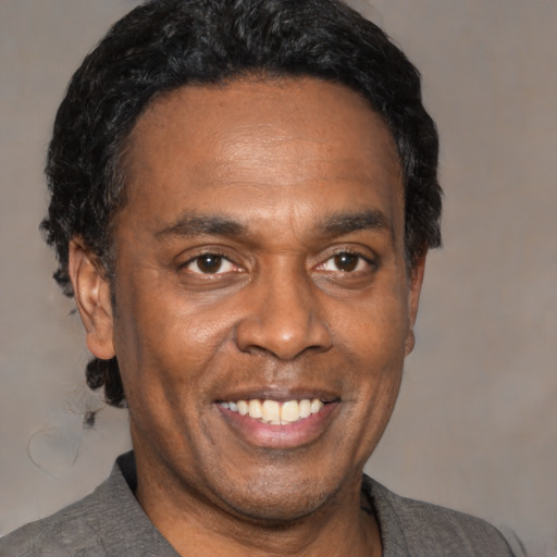 Joyful black adult male with short  black hair and brown eyes