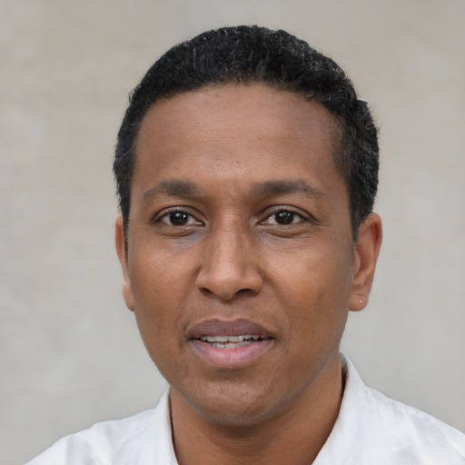 Joyful black adult male with short  black hair and brown eyes