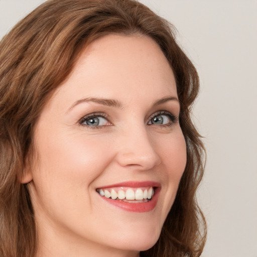 Joyful white young-adult female with long  brown hair and green eyes