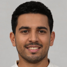 Joyful latino young-adult male with short  black hair and brown eyes