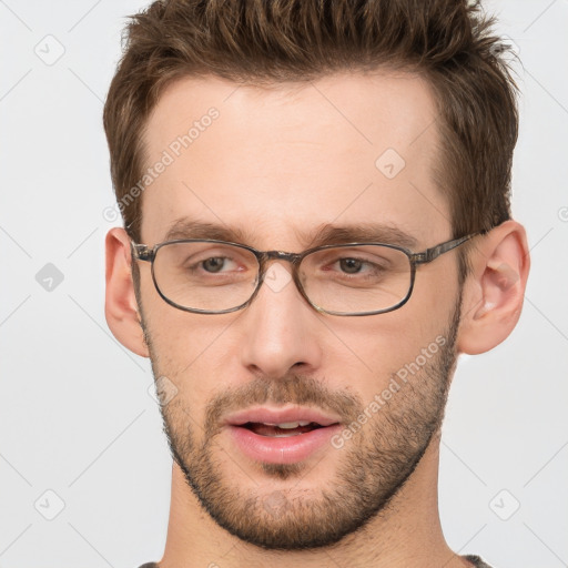 Joyful white adult male with short  brown hair and grey eyes