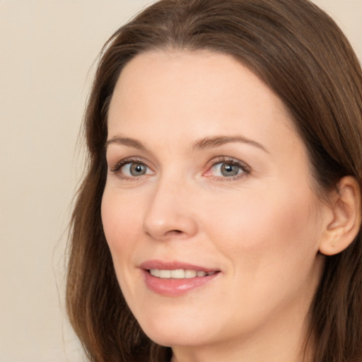 Joyful white adult female with long  brown hair and brown eyes