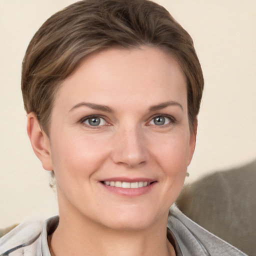 Joyful white young-adult female with short  brown hair and grey eyes