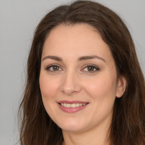 Joyful white young-adult female with long  brown hair and brown eyes