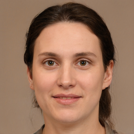 Joyful white young-adult female with medium  brown hair and green eyes