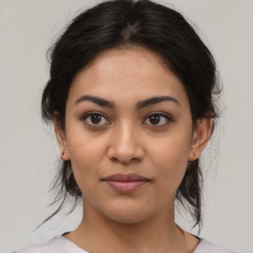 Joyful latino young-adult female with medium  brown hair and brown eyes
