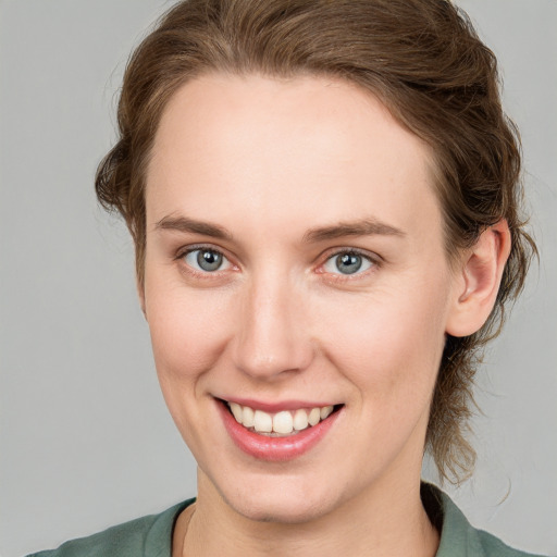 Joyful white young-adult female with medium  brown hair and blue eyes