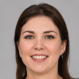 Joyful white young-adult female with long  brown hair and brown eyes