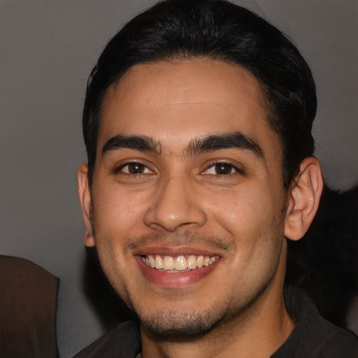 Joyful latino young-adult male with short  black hair and brown eyes