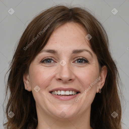 Joyful white adult female with long  brown hair and grey eyes