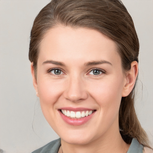 Joyful white young-adult female with medium  brown hair and grey eyes