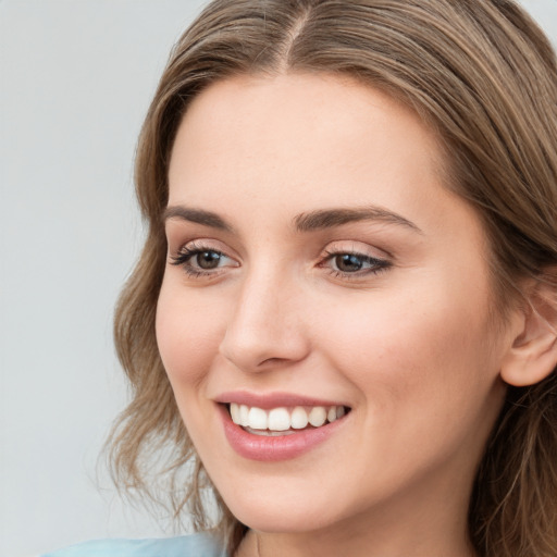 Joyful white young-adult female with long  brown hair and grey eyes