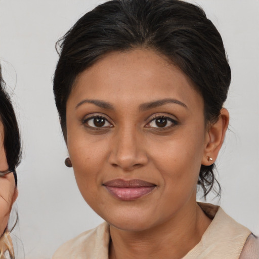 Joyful black young-adult female with medium  brown hair and brown eyes